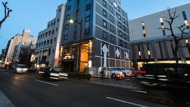 A modern hotel with a prominent 'HOTEL' sign, multiple floors, and a well-lit entrance.