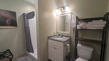 A bathroom with a sink, mirror, toilet, and towel rack.