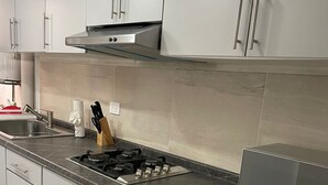 Una cocina moderna con gabinetes grises, estufa a gas y microondas integrado.