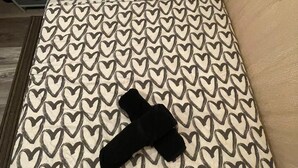 A bed with a white and black heart pattern, a black pillow, and a beige wall. - Petite and Private Little Place (Lake Isabella)
