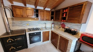 Une cuisine avec des meubles de rangement en bois, une cuisinière à gaz, un four et un four à micro-ondes.