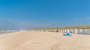 En strand med en række hvide strandhuse og en sandstrand.
