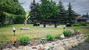 A garden with a stone pathway, benches, and a gazebo.
