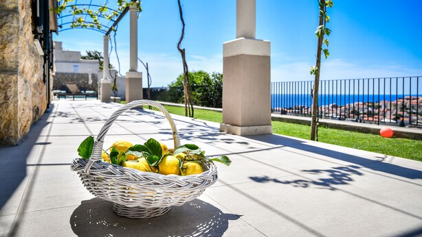 A wicker basket with lemons on a tiled surface, under a pergola with a view of the sea. - Beautiful peaceful villa with a pool in the center of Dubrovnik (Dubrovnik)