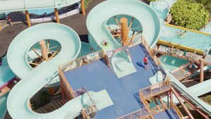 Een waterpark met meerdere glijbanen en een centraal zwembad.