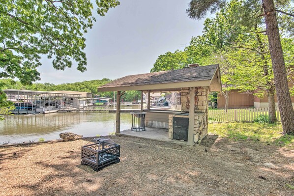A covered outdoor seating area with a view of a water body and a dock. - Dock! Waterfront Family Home on Lake of the Ozarks (Lake Ozark)