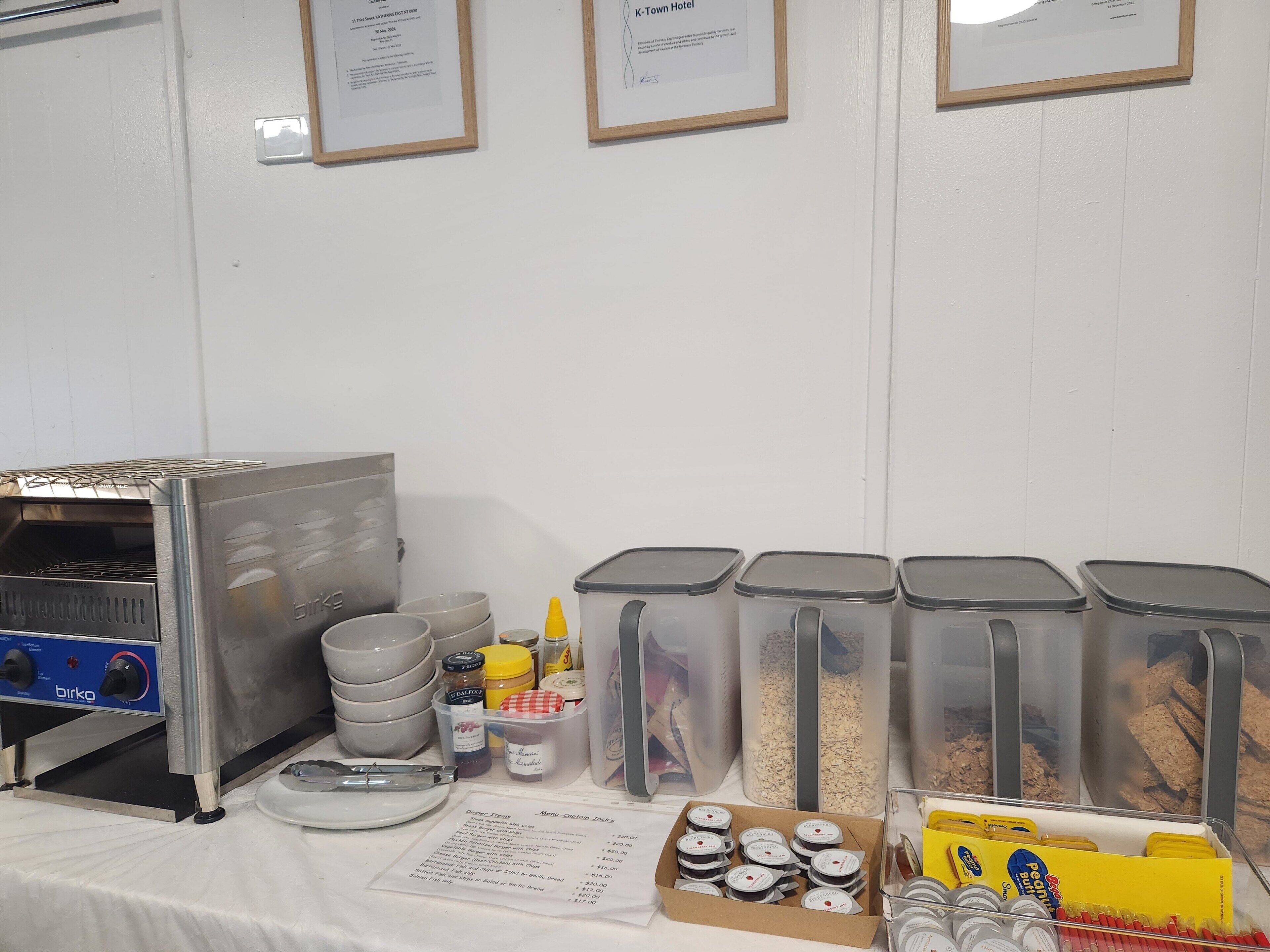 Uma área de cozinha com forno Birko, recipientes de armazenamento e um cardápio.