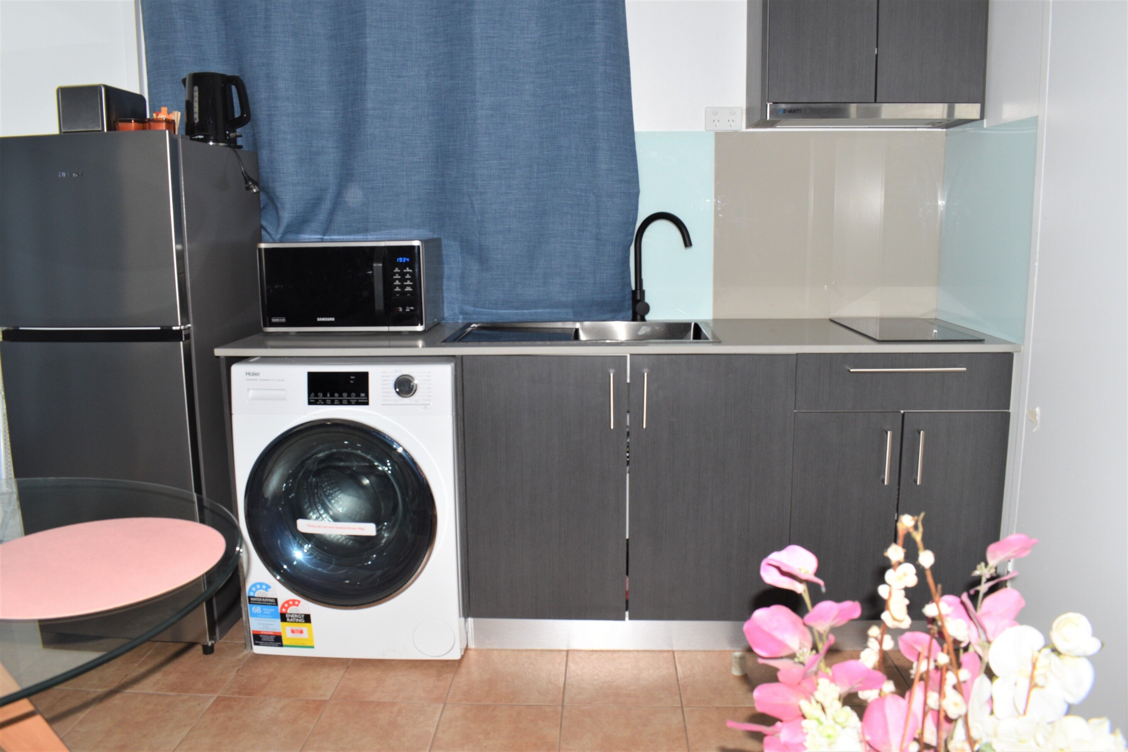 Cuina compacta amb rentadora, microones i rentaplat.