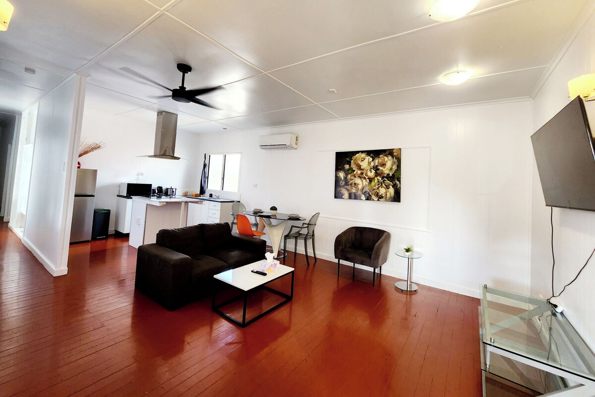 A modern living room with a sofa, coffee table, and a glass TV stand.