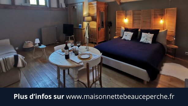Una camera accogliente con un letto grande, un tavolo da pranzo con sedie e un piccolo angolo relax.