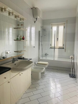 Kombination af bruser/badekar, hårtørrer, bidet, håndklæder