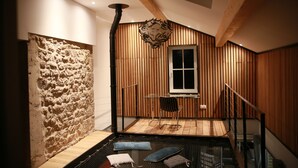 A modern interior with a wooden slatted wall, a glass table, and a chair.