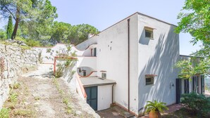 Ein weißes Gebäude mit Steinwand und kleinem Garten.