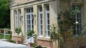 A stone building with large windows and a brick base. - The Orangerie in the grounds of Chateau St Justin (Saint-Justin)