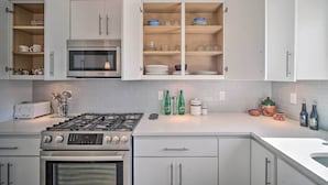 A modern kitchen with white cabinets, a Bosch oven, a microwave, and a gas stove. - Upper Valley El Paso Home w/ Hiking Access On-Site (El Paso)