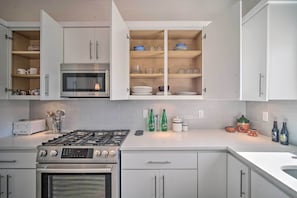 A modern kitchen with white cabinets, a Bosch oven, a microwave, and a gas stove. - Upper Valley El Paso Home w/ Hiking Access On-Site (El Paso)