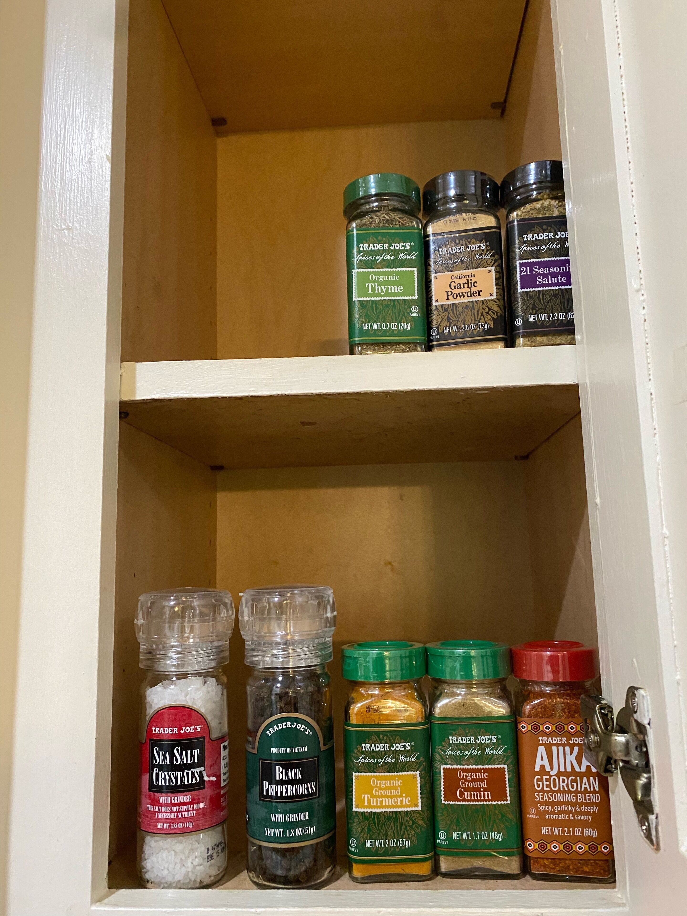 A spice cabinet with various jars of spices and seasonings.
