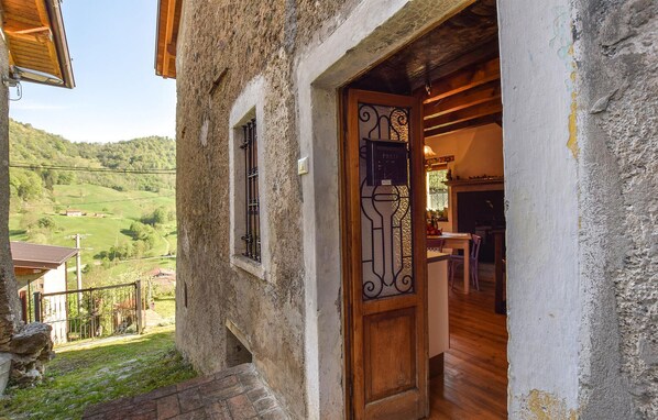 Un edificio rústico de piedra con una puerta de madera que da a un espacio interior con comedor.