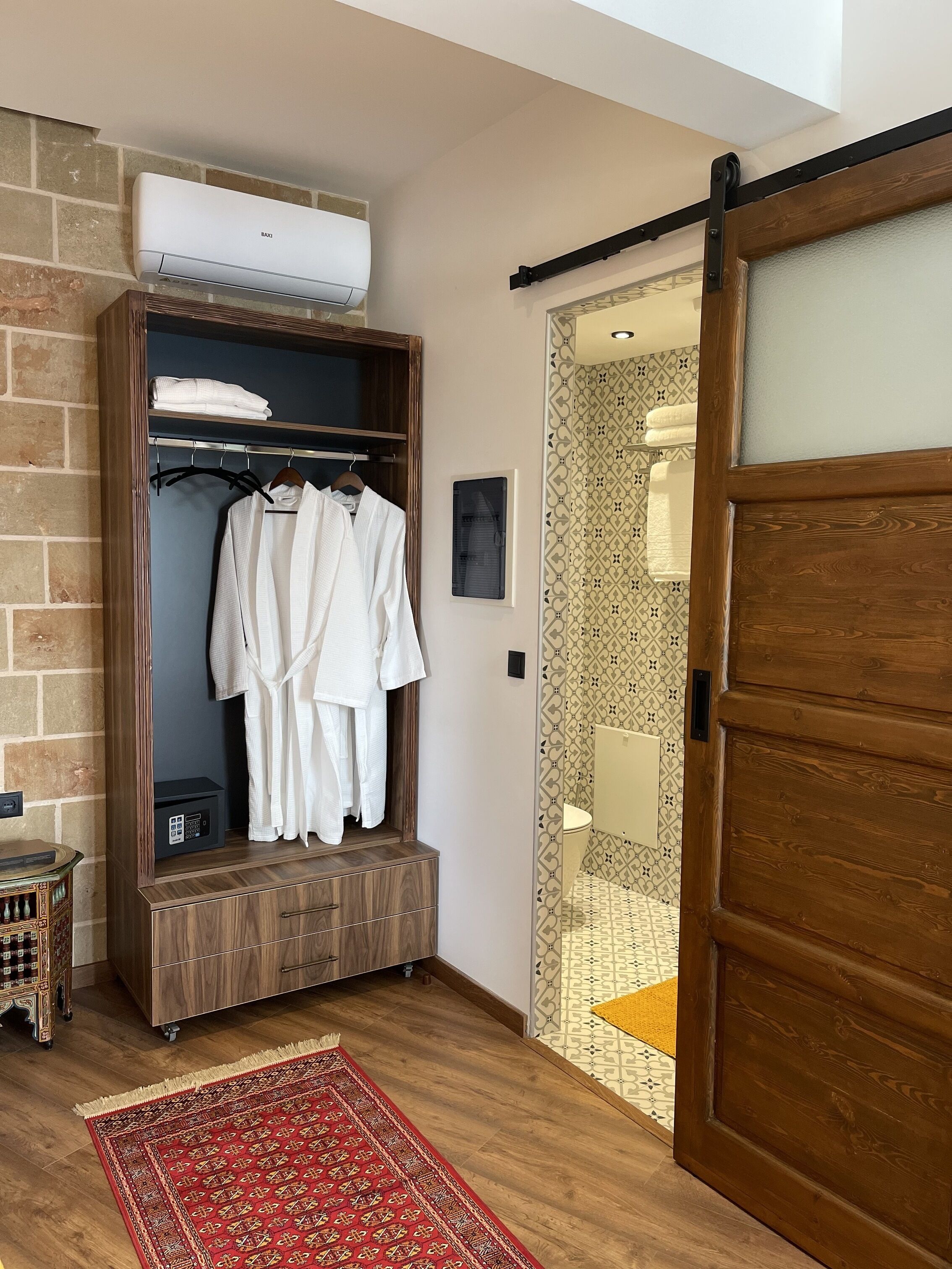 Um closet espaçoso com roupeiro, aquecedor embutido e piso de madeira.