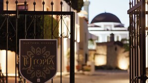 Una entrada vigilada con un cartel que dice 'Old Town Rhodes' y una mezquita al fondo.