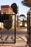 Una entrada vigilada con un cartel que dice 'Old Town Rhodes' y una mezquita al fondo.