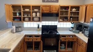 Una cocina con armarios de madera, estufa, pileta y encimera.