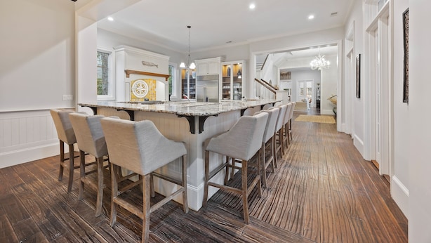 A spacious kitchen with a central island, bar stools, and a wooden floor. - Gorgeous 2nd row home directly on the beach path in Palmetto Dunes with pool (Hilton Head Island)