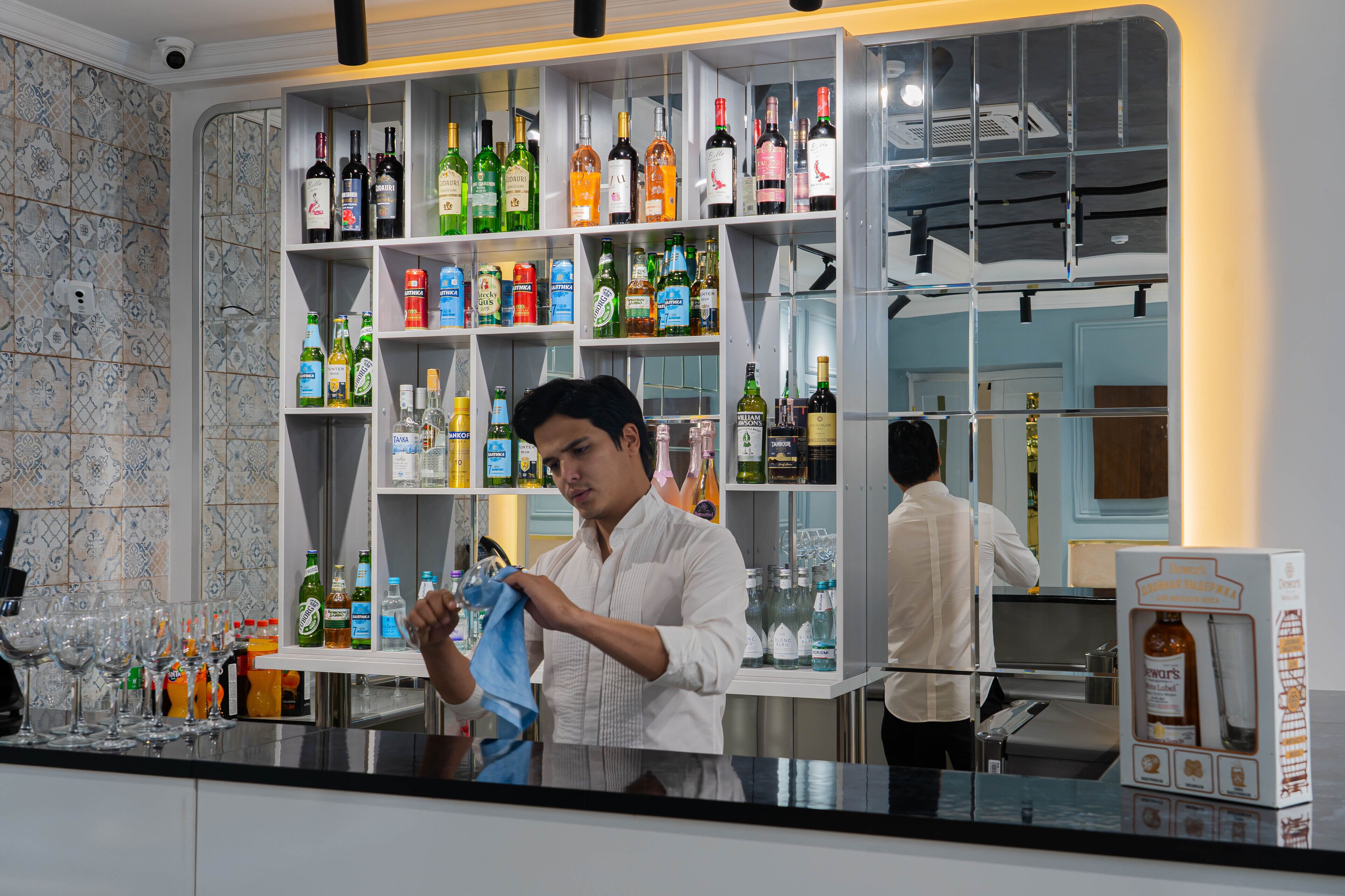 A bar area with shelves of various liquor bottles and glasses.