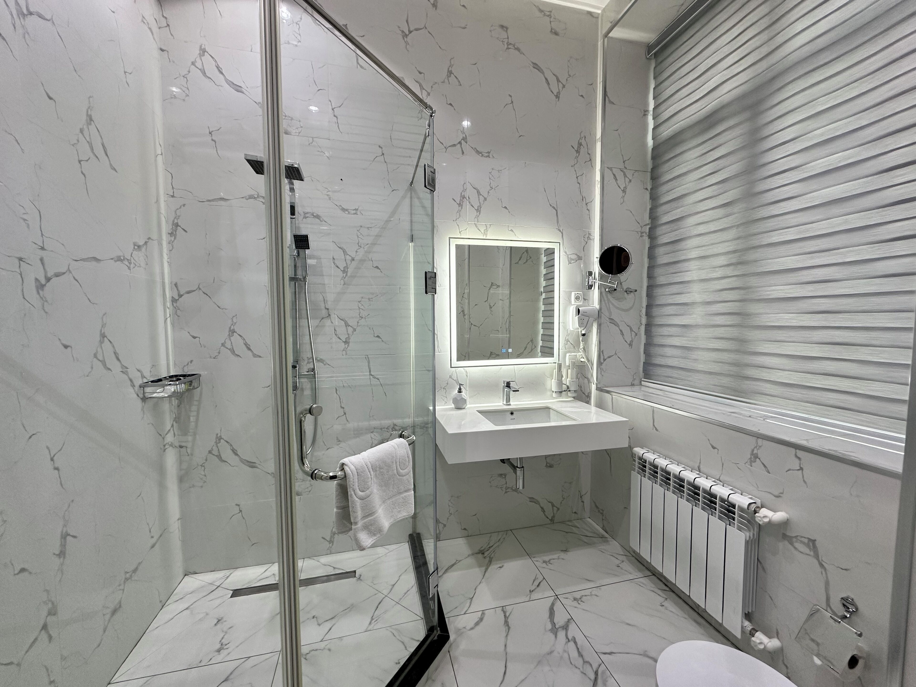 A modern bathroom with a glass-enclosed shower, a vanity with a mirror, and a toilet.