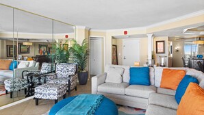 A living room with a sofa, armchairs, a coffee table, and a large mirror. - Ocean View, recently updated, 24 hour security + Free Attraction Tickets! (Myrtle Beach)