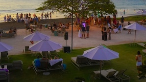 A beachside venue with outdoor seating, umbrellas, and a view of the sea. - Chic Condo w/ Sparkling Pool & Lush Mountain Views from Shaded Balconies (Playas del Coco)