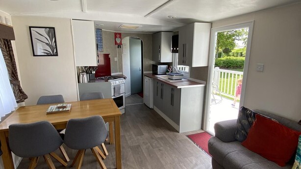 A compact living space with a dining area, kitchenette, and a sofa.
