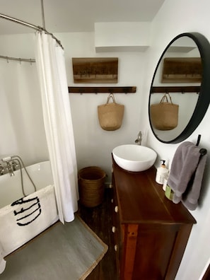 Een bad/douchecombinatie, handdoeken, zeep, toiletpapier