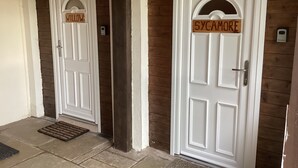 Deux portes blanches avec des panneaux de bois, l’une portant l’inscription « WILLOW » et l’autre « SYCAMORE ».