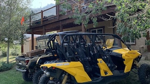 Un quad Polaris Ranger groc estacionat davant d'un edifici de fusta amb un balcó.