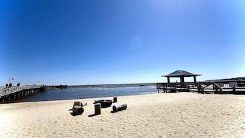 Vlak bij het strand, ligstoelen aan het strand, parasols, strandlakens