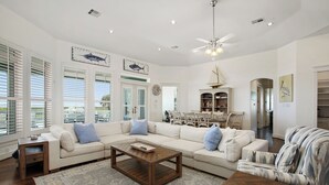 A spacious living room with a sectional sofa, a coffee table, and a patterned rug. - The Blue Pete - Book 7 nights get the last night free. 5BD/3.5 BA. Sleeps 15 (Galveston)