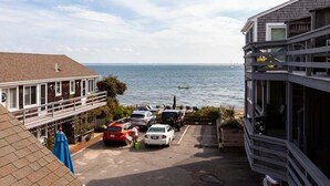 Um imóvel costeiro com área de estacionamento, um edifício com varanda com vista para o mar e vista do oceano.