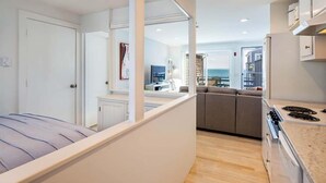 Espaço compacto para viver, com cozinha compacta, sofá e cama.