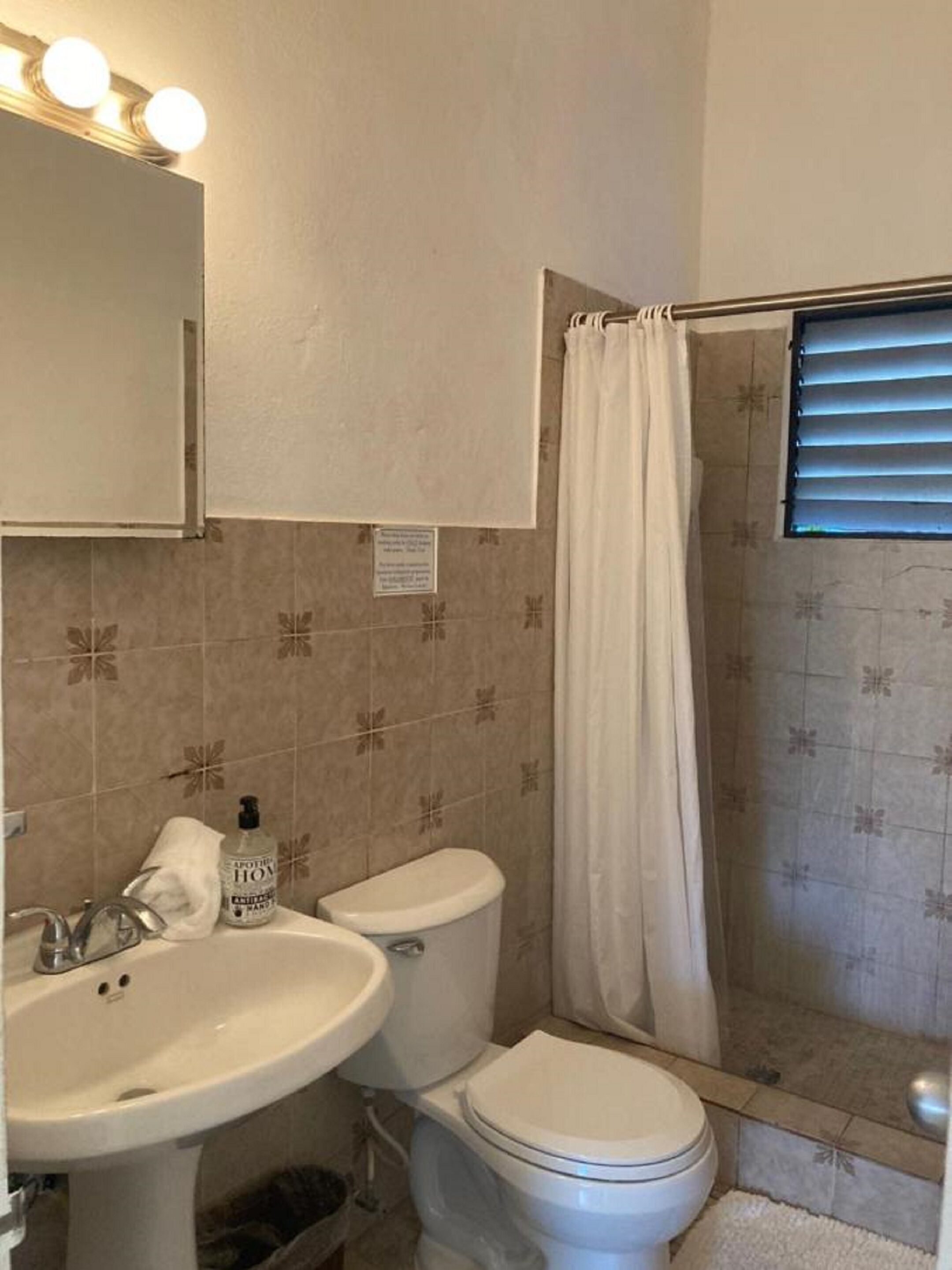 Un baño con lavabo, inodoro y cortina de ducha.