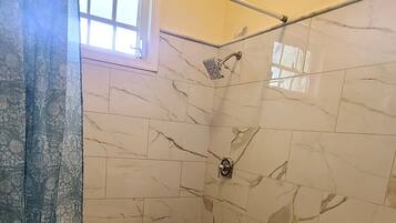 A bathroom with a shower, toilet, and sink.