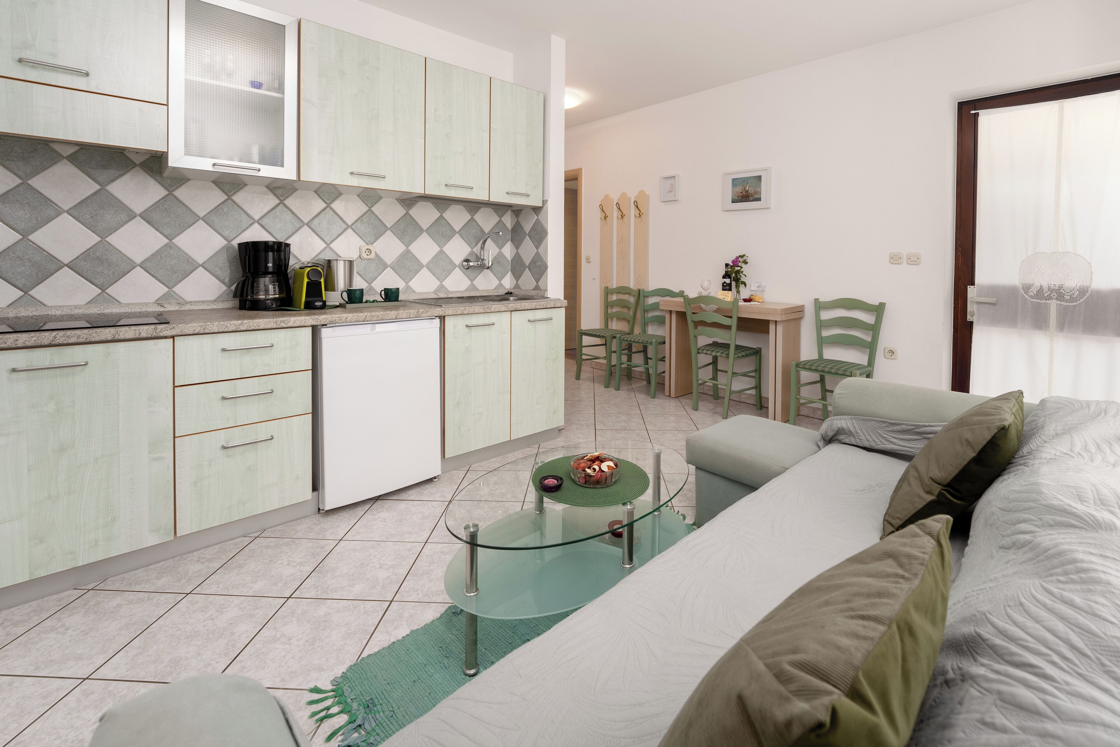 Un espacio habitable compacto con kitchenette, comedor y zona de estar.