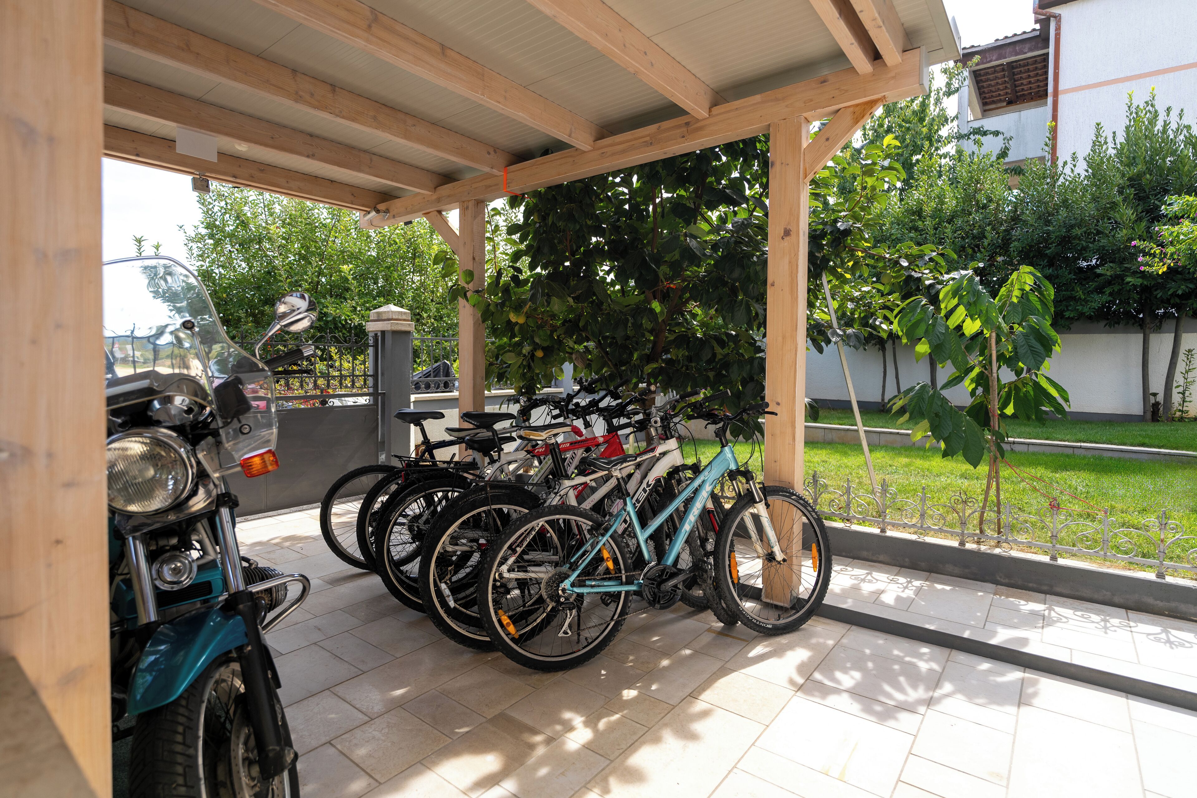 Un área de estacionamiento cubierto para bicicletas y una motocicleta.