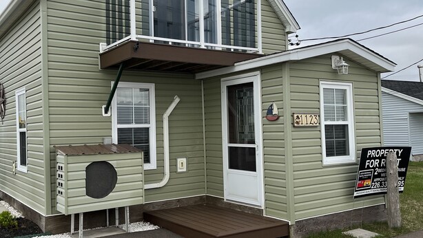 A two-story house with a front porch, a balcony, and a small attached garage.
