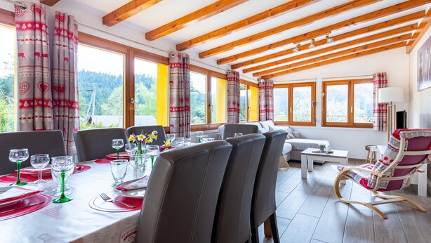 Un comedor con techo de madera, ventanas amplias y vistas al exterior.