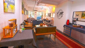A hotel lobby with seating, a coffee station, and a view of the street. - Kondoskali Hotel (Istanbul)