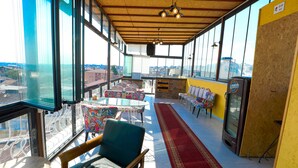 A high-ceilinged room with large windows, a red carpet, and a television. - Kondoskali Hotel (Istanbul)