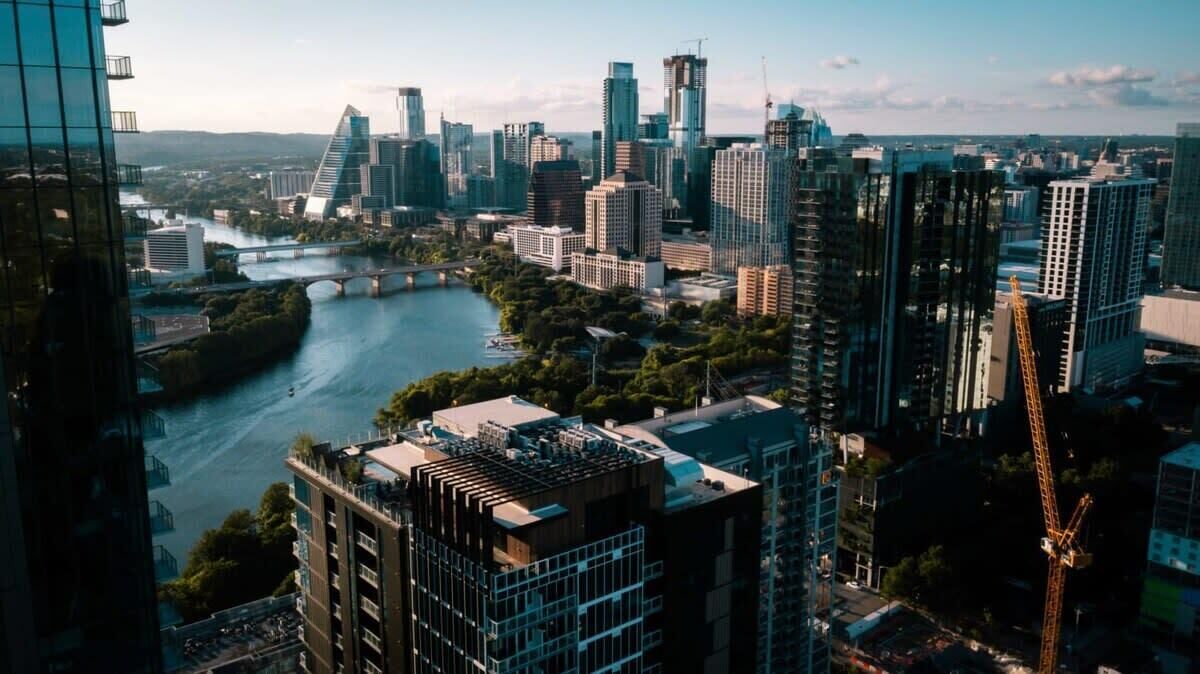A cityscape with modern high-rise buildings, a river, and a bridge.