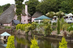 Traditional cottages nestled among lush gardens and a serene lake.