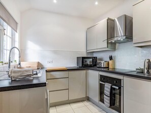 Effortlessly cook and entertain in this well-equipped kitchen with a stainless steel range hood, dishwasher, microwave, and toaster.